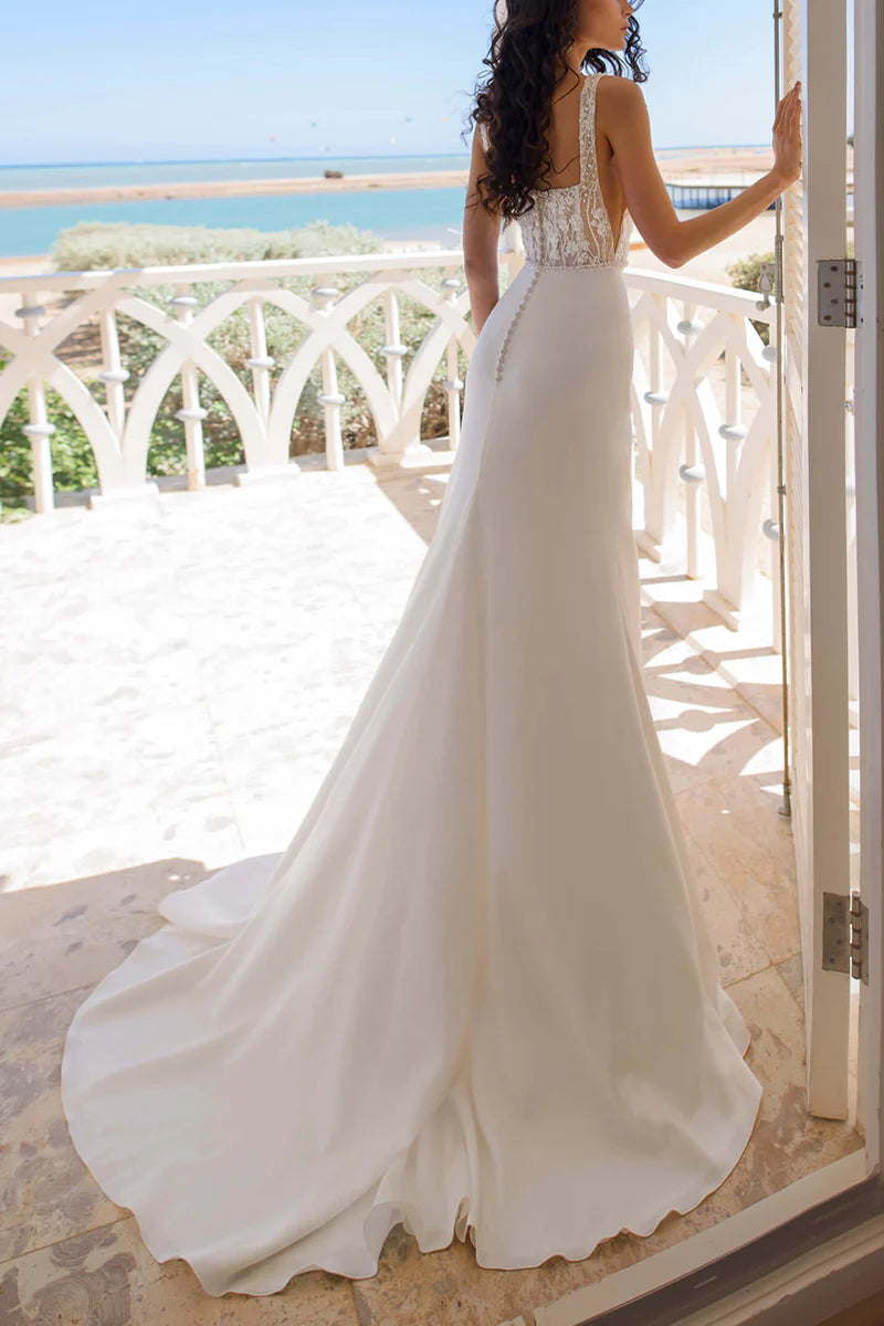 Close-up of the lace detailing and square neckline of the boho wedding dress.