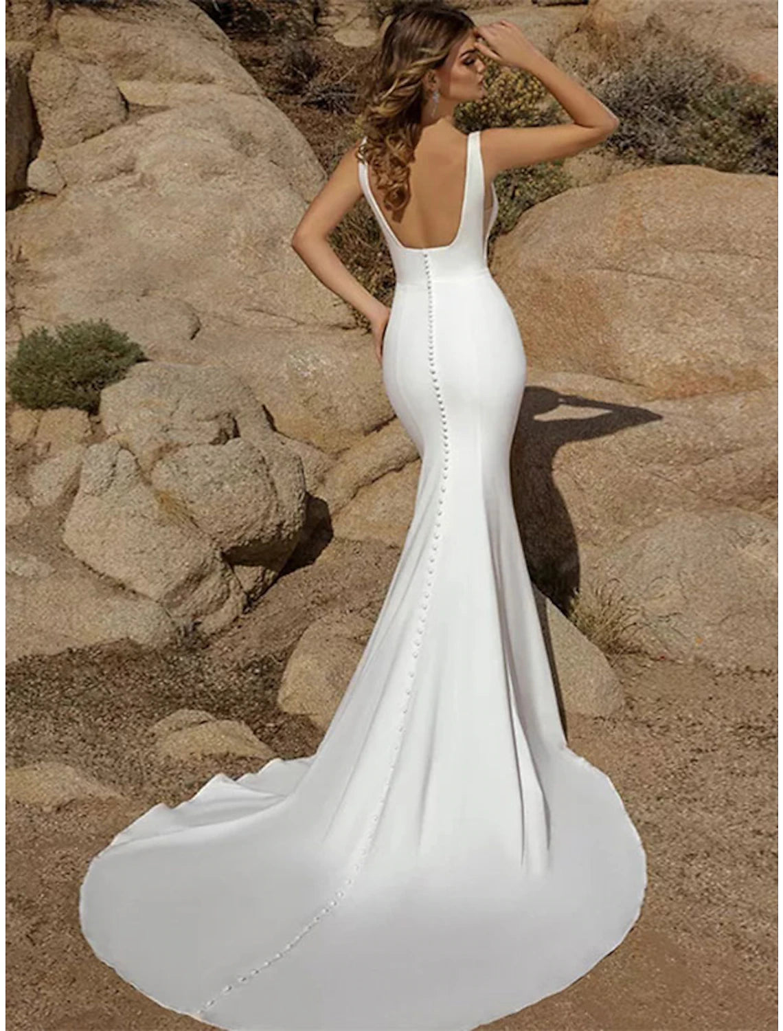 Back view of the mermaid wedding dress, highlighting the open back and button details.