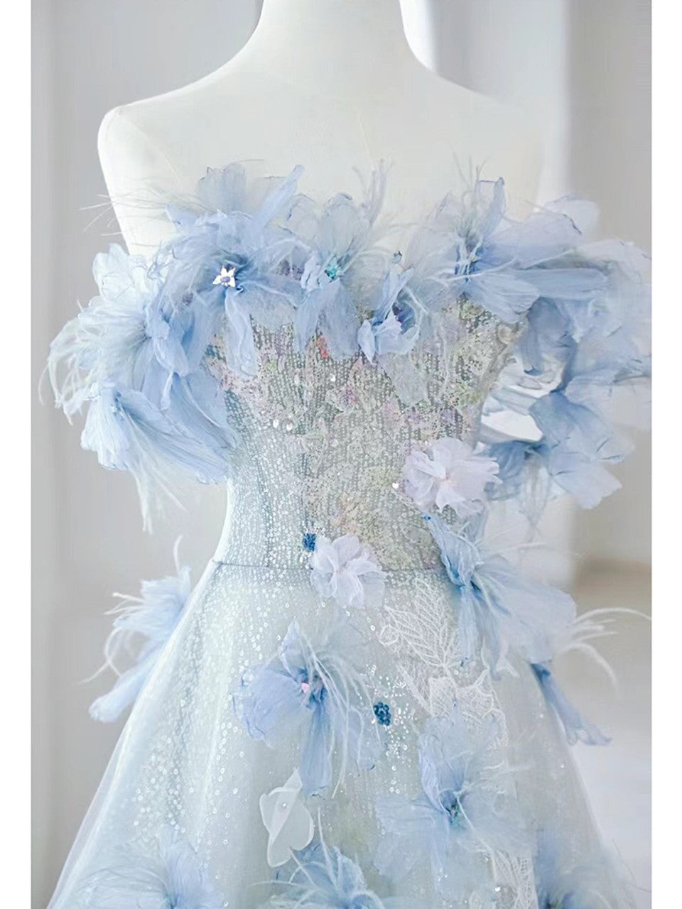 Close-up of the floral details and tulle fabric on the off-shoulder prom dress.
