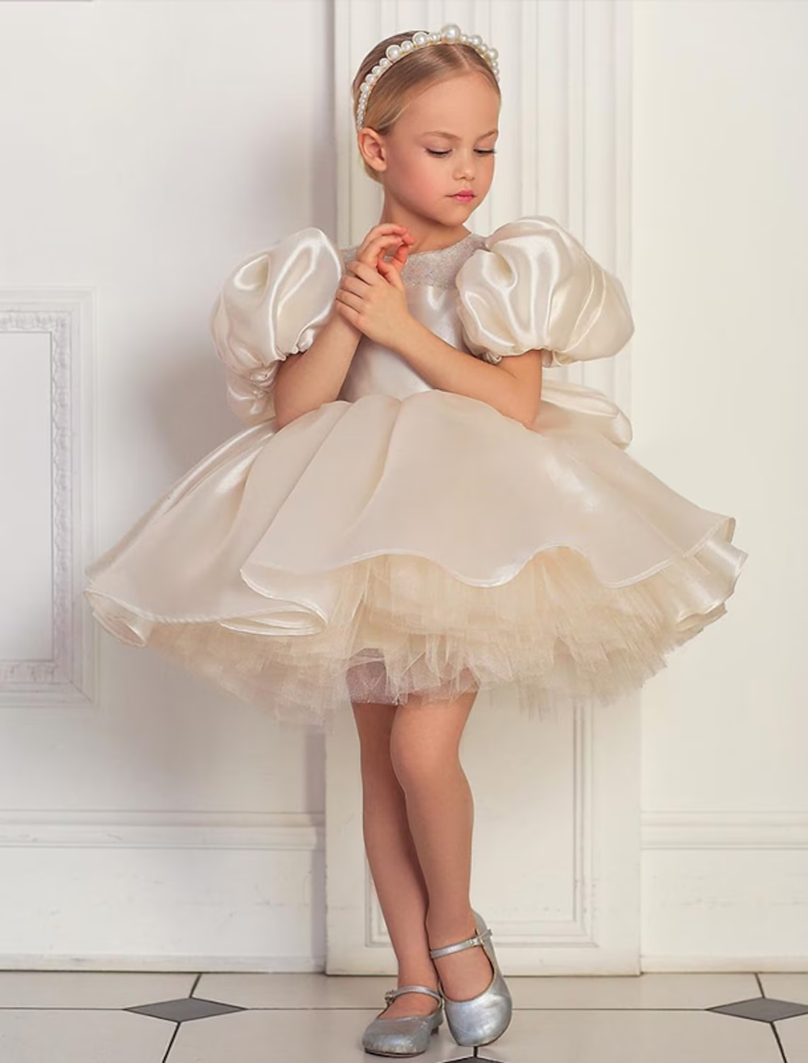 Close-up of white puff sleeve dress with sequin details.