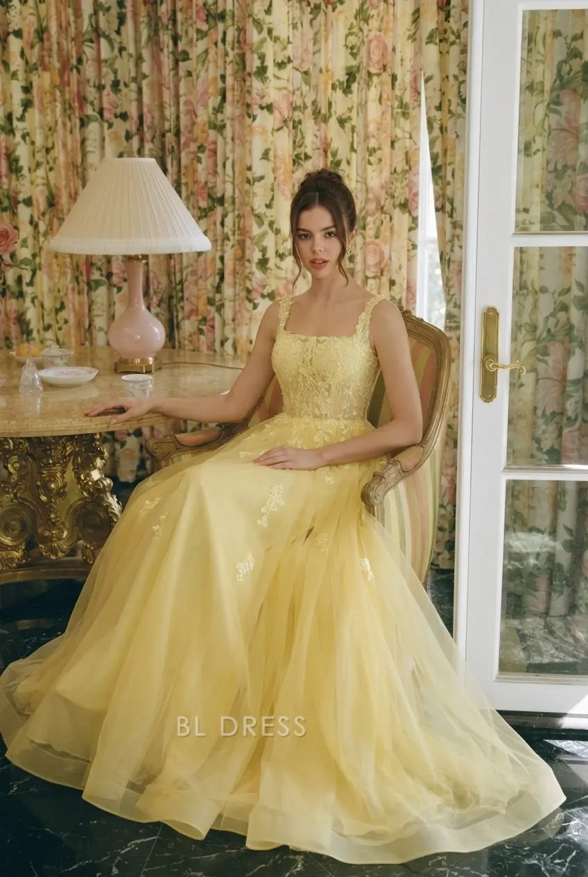Full length view of sleeveless yellow prom gown with tulle skirt.