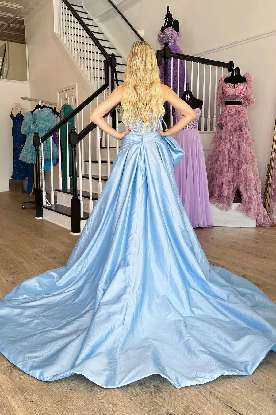 Back view of a light blue satin prom dress showing the court train.