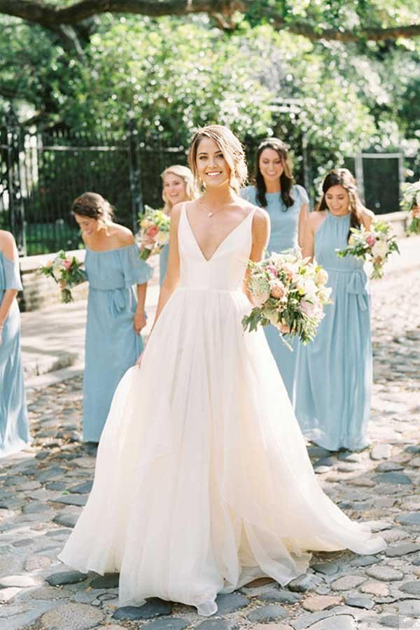 Full view of an ivory A-line V-neck backless wedding dress made of tulle.
