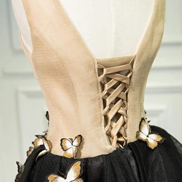 Close-up of black V-neck homecoming dress showing butterfly embellishment.