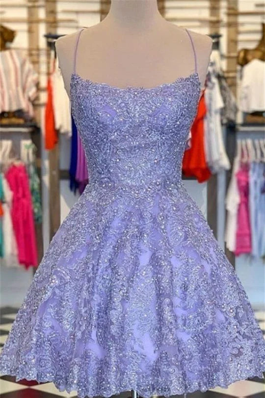 Elegant V-neck spaghetti strap homecoming dress with tulle, applique, and beaded lace details.