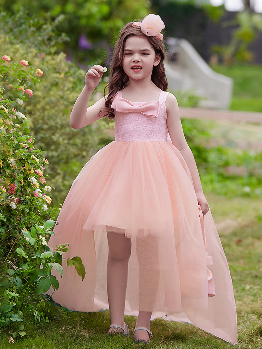 Flower girl in an elegant white ball gown with scoop neck and 3/4 sleeves, featuring a large bow at the back.