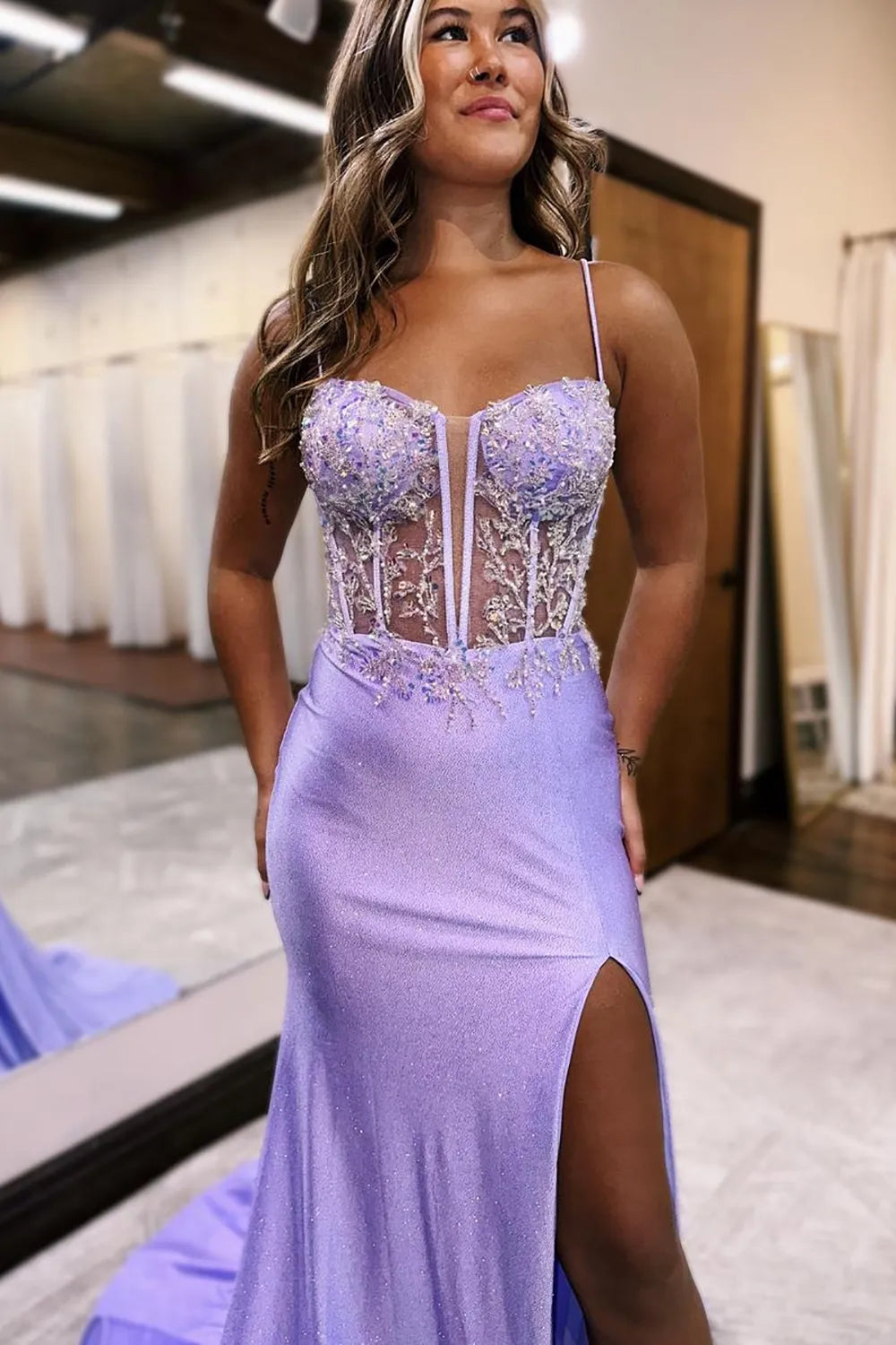 Full length view of a lilac mermaid prom dress with a flowing slit.