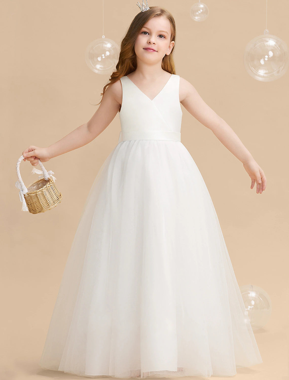 Young girl wearing a white long sleeve princess tulle maxi dress with a backless bow.