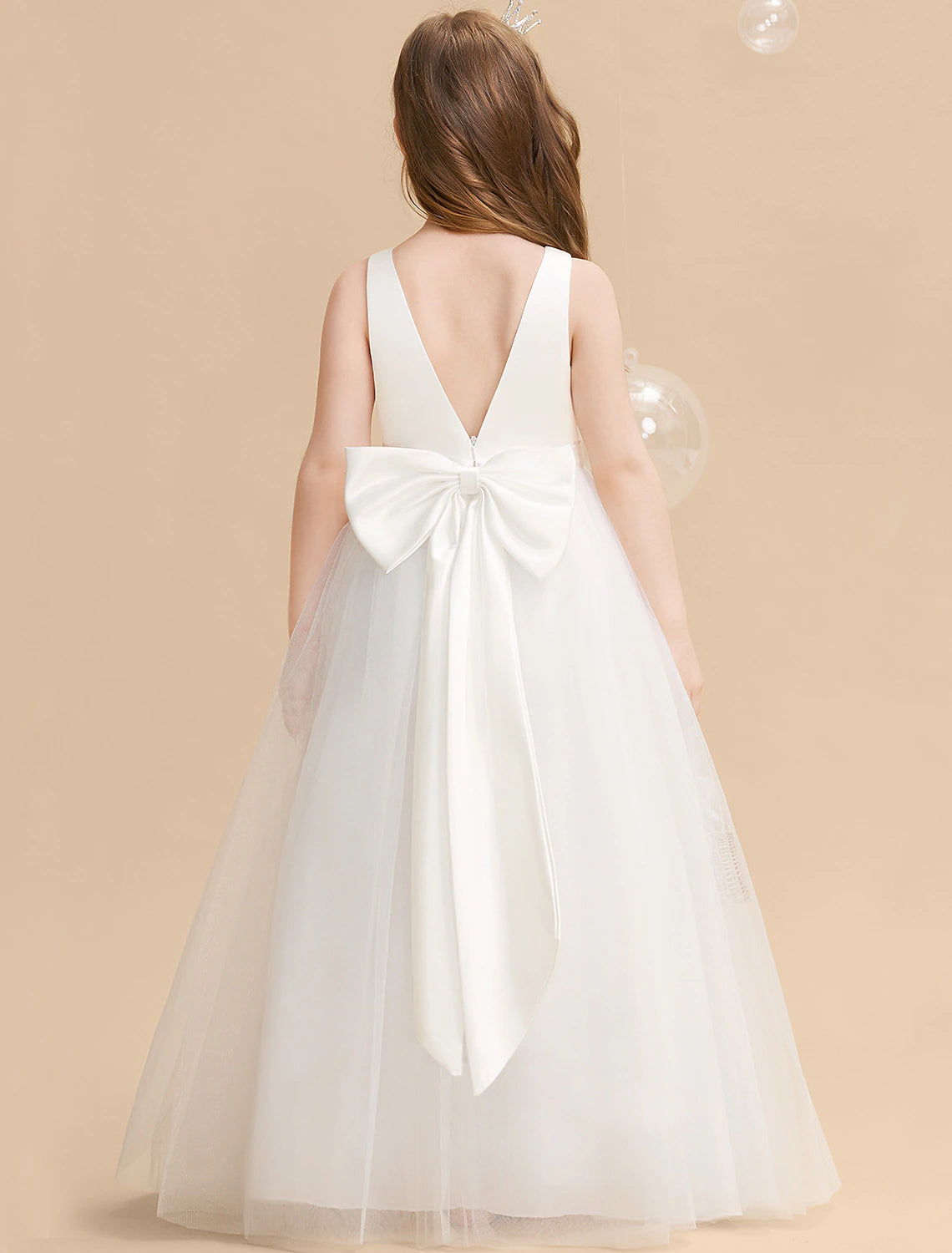 Young girl wearing a pink long sleeve princess tulle maxi dress with a backless bow.