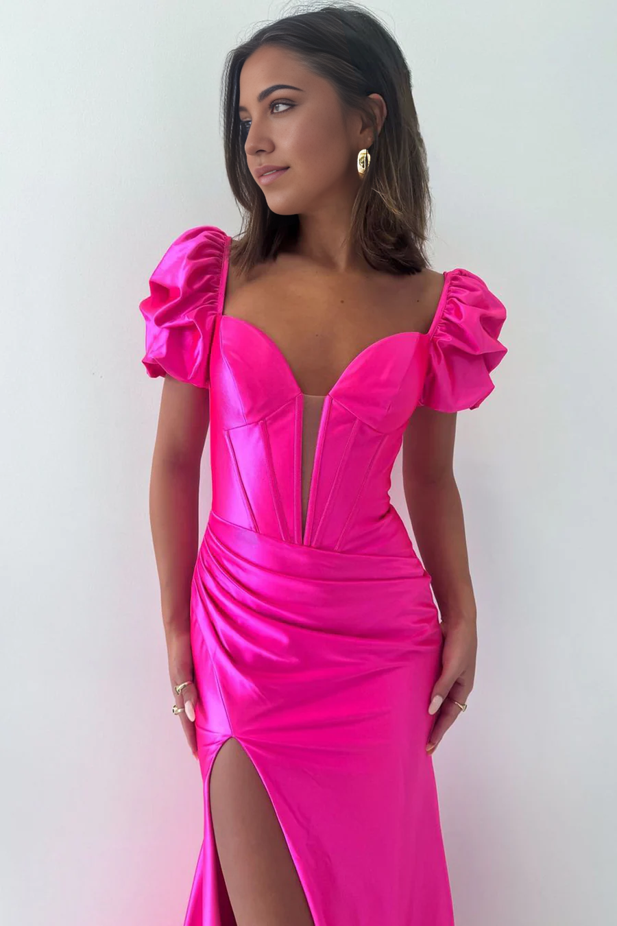Side view of a model in a hot pink mermaid V-neck satin long formal dress.