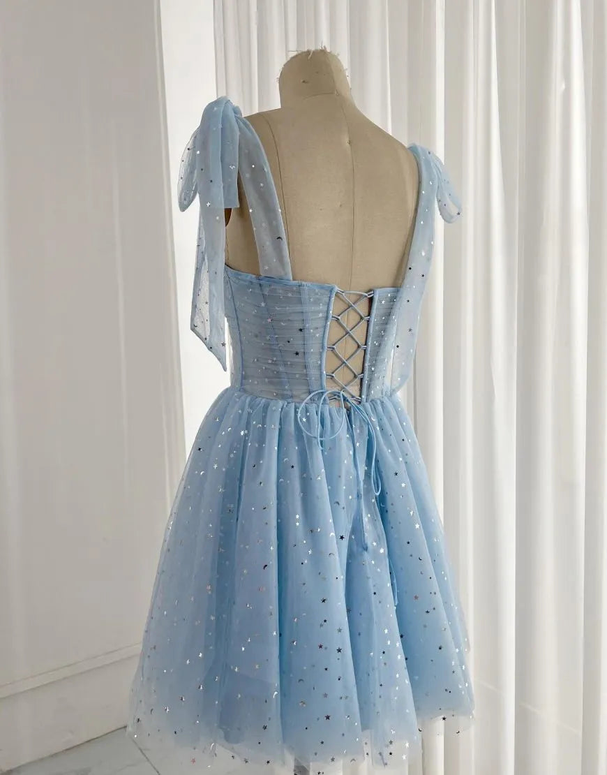 Back view of a short homecoming dress featuring a detailed corset closure and tie straps.
