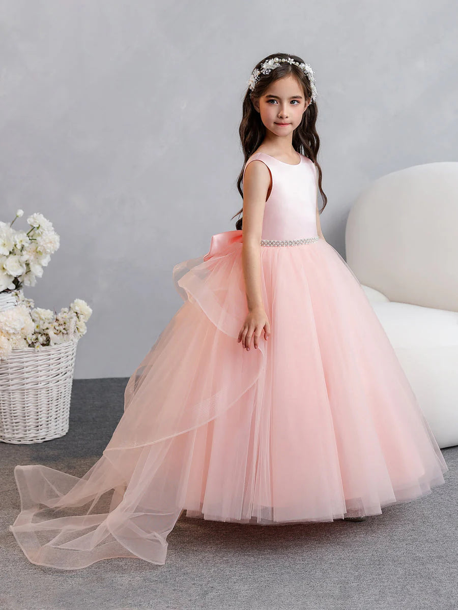 Back view of a flower girl dress showing a large bowknot and ruffled tulle skirt.