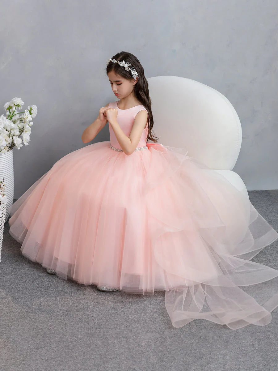 Close-up of the bodice and pearl details on a white flower girl dress.