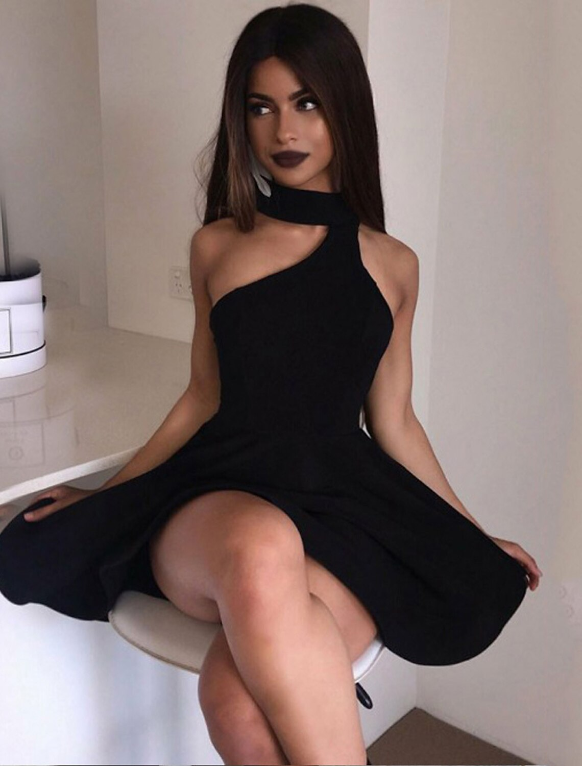 Side view of a minimalist pleated mini dress.