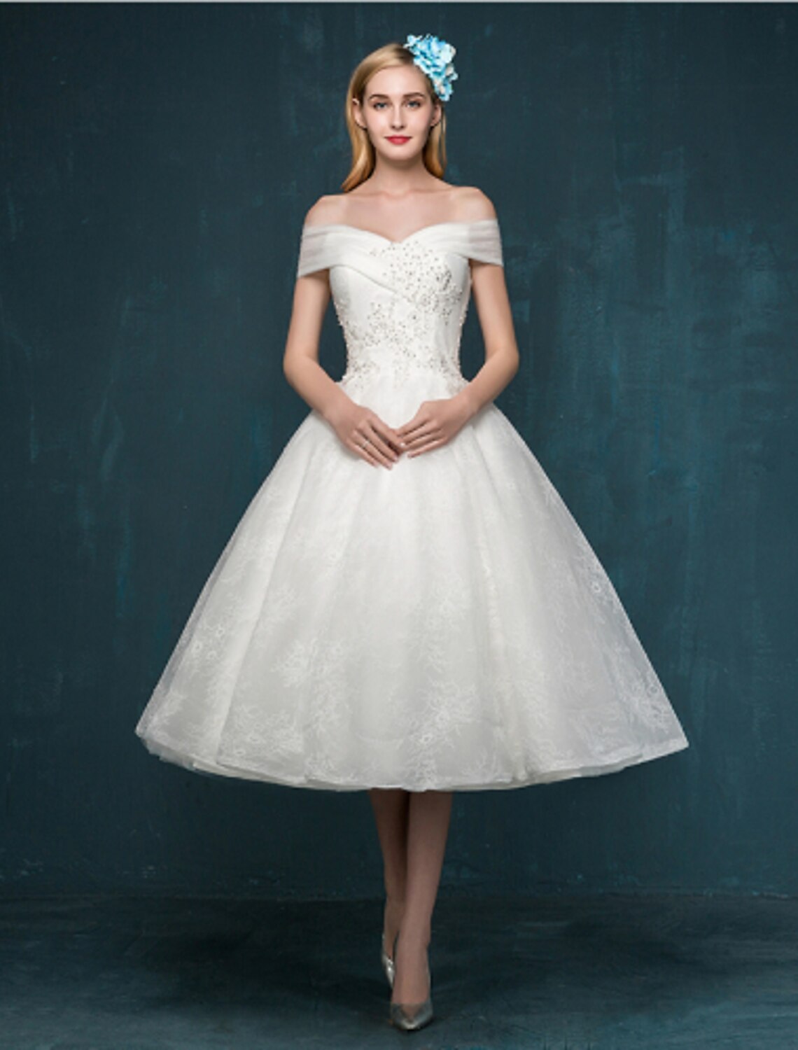 White A-Line off-shoulder cap sleeve tea length lace dress with beading and sequins.