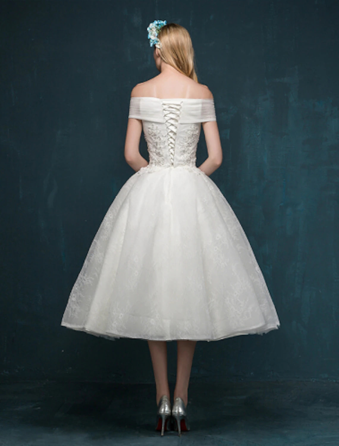 Side view of the elegant white tea length bridal gown.
