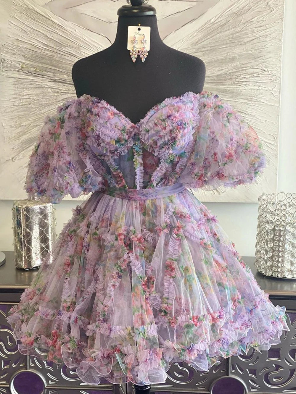 Model wearing a chic A-line off-shoulder floral printed knee-length homecoming dress.