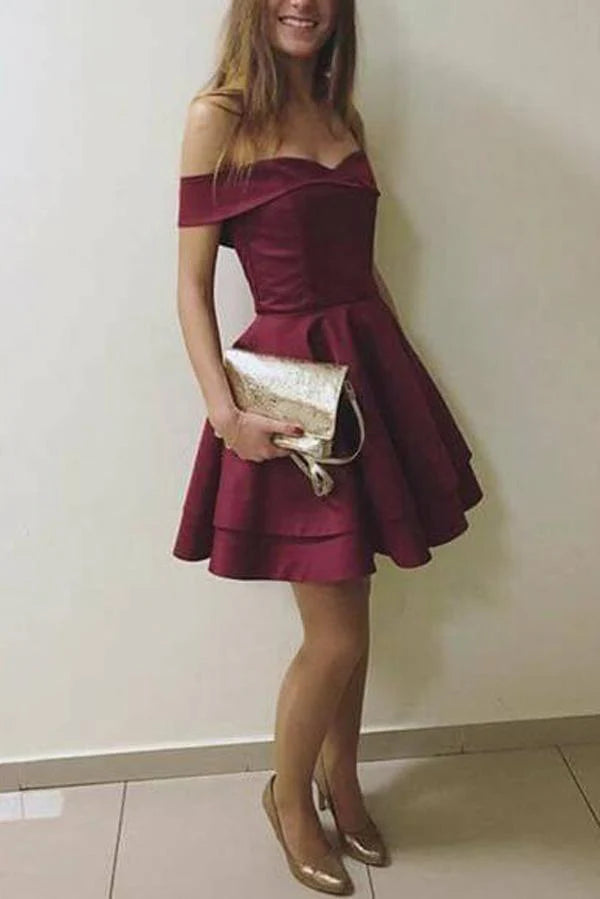 Woman wearing an A-line off-the-shoulder short homecoming dress.