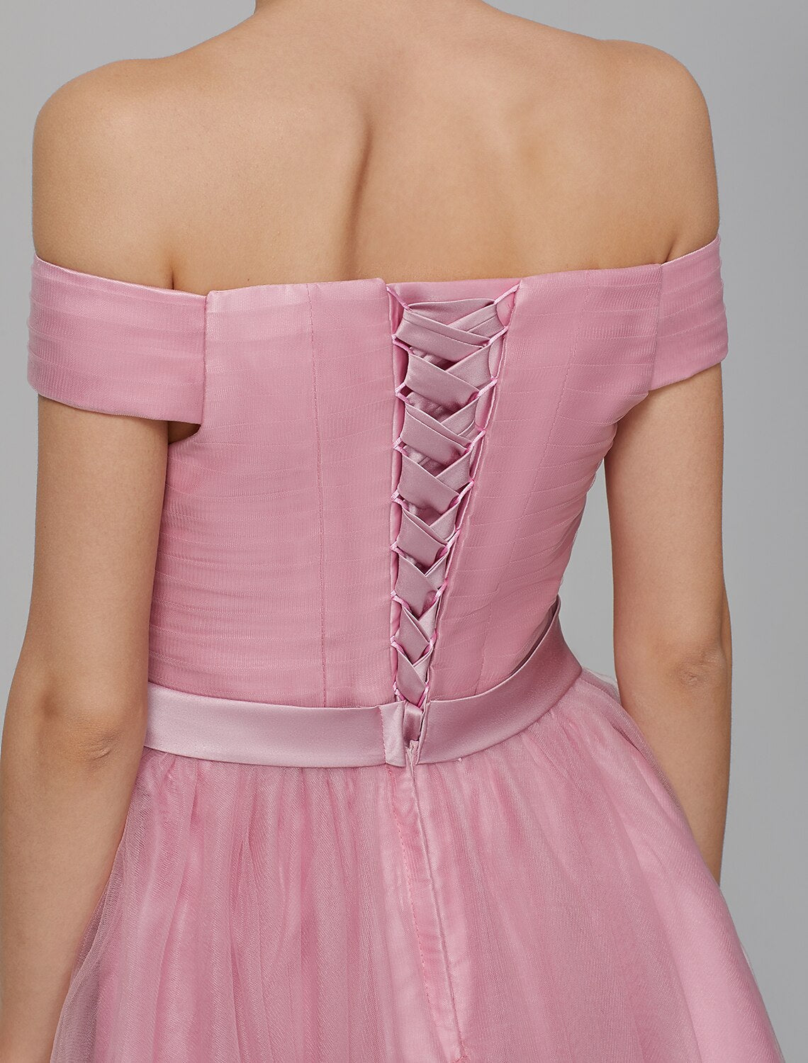 Close-up of the off-shoulder neckline and sash detail on the dress.