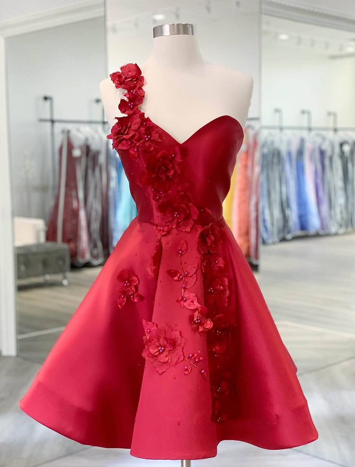 Front view of an A-line one-shoulder satin short homecoming dress with appliques.
