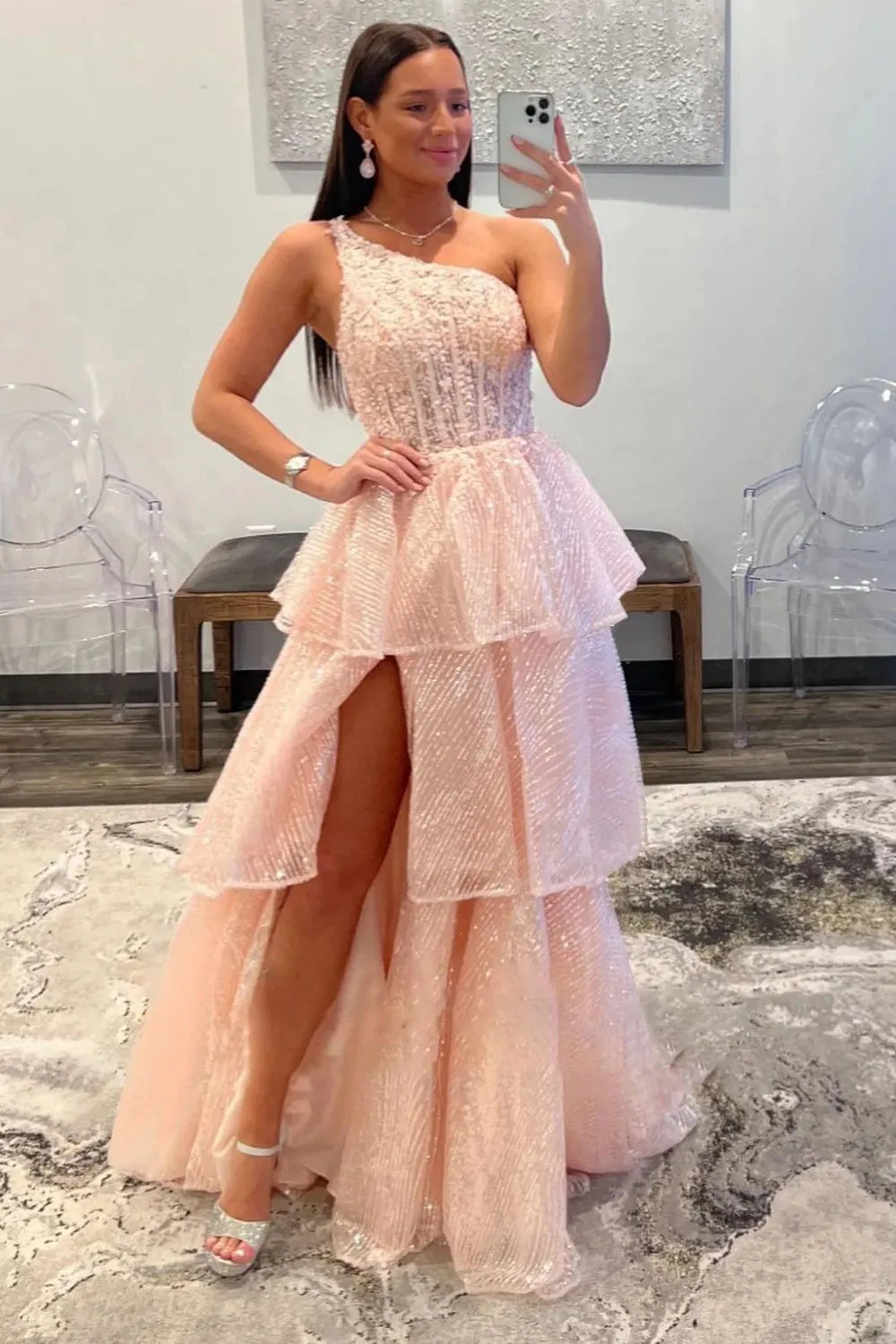 Model wearing an elegant A-line one-shoulder long prom dress with ruffles.