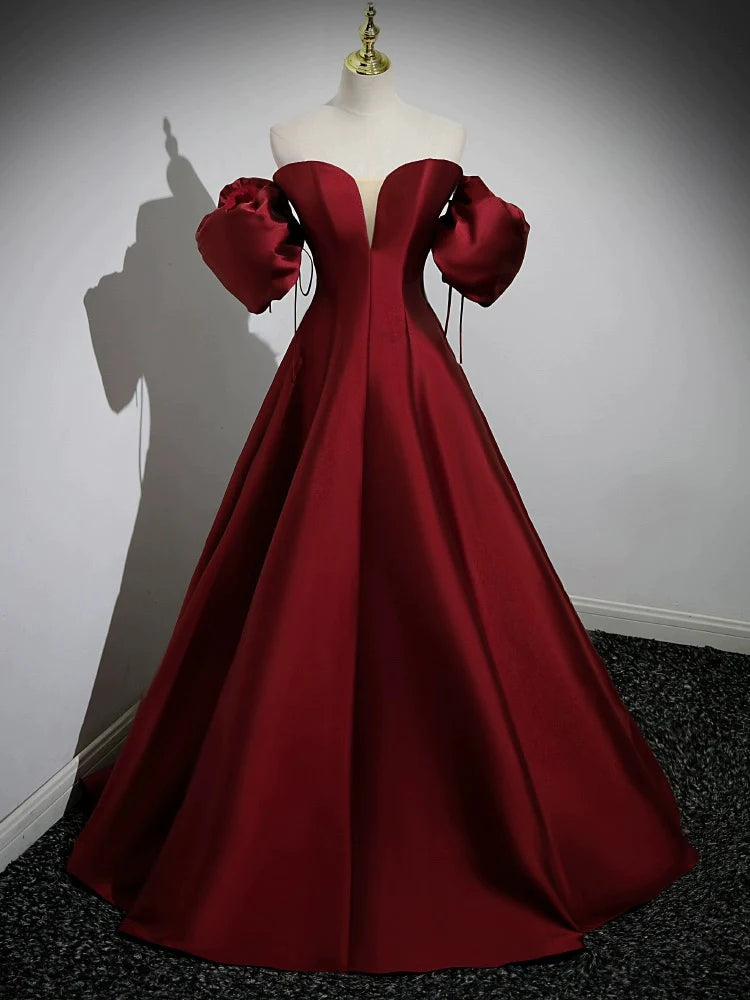 Model wearing a long A-line satin prom dress with puff sleeves.