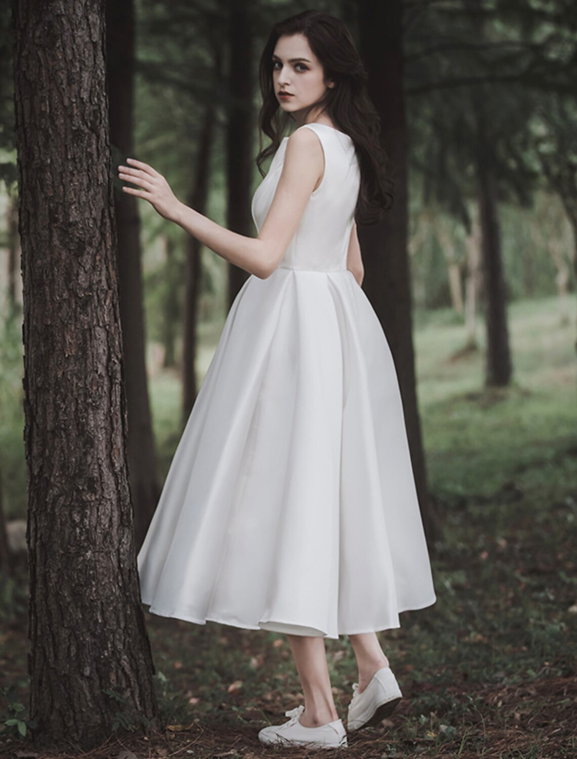 Back view of a white A-line satin tea length bridal gown.