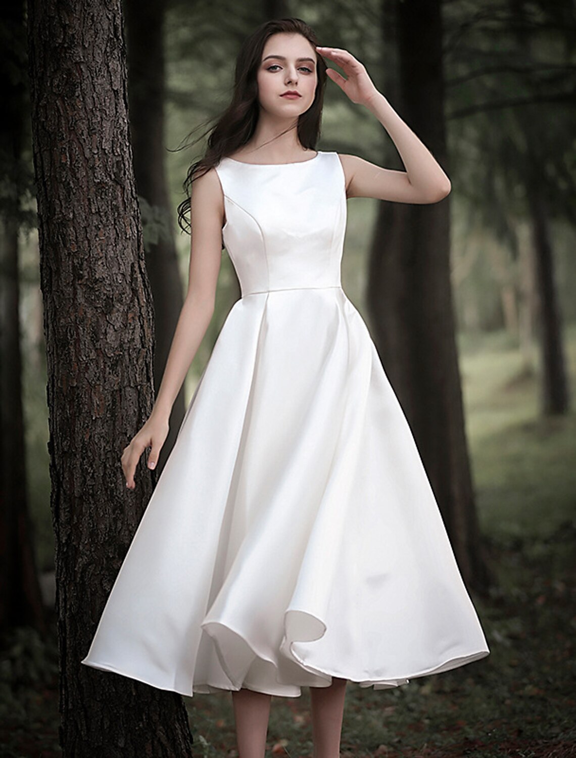 Side view of a sleeveless white satin scoop neck reception dress.
