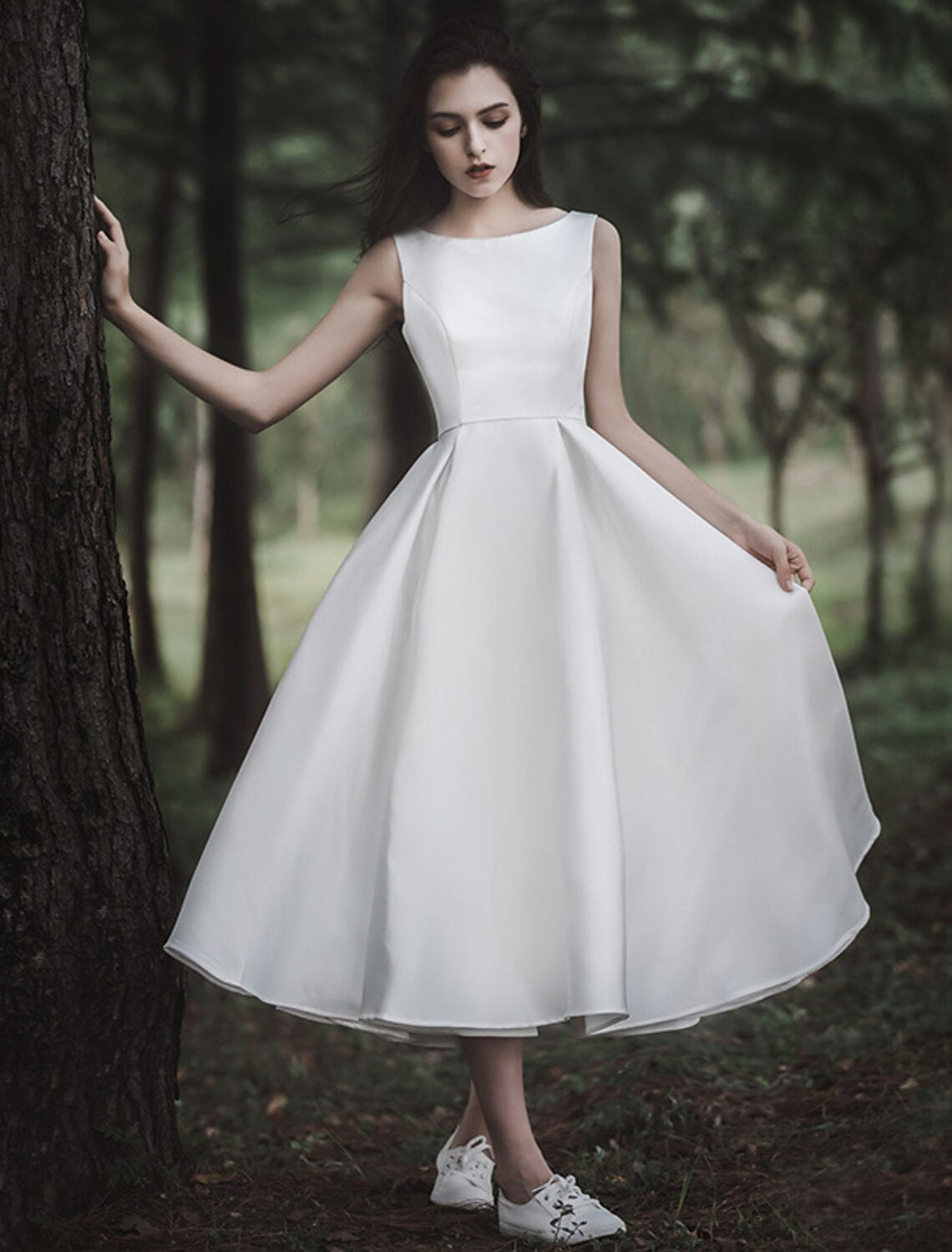 Close-up of the satin fabric and scoop neckline on a white wedding dress.