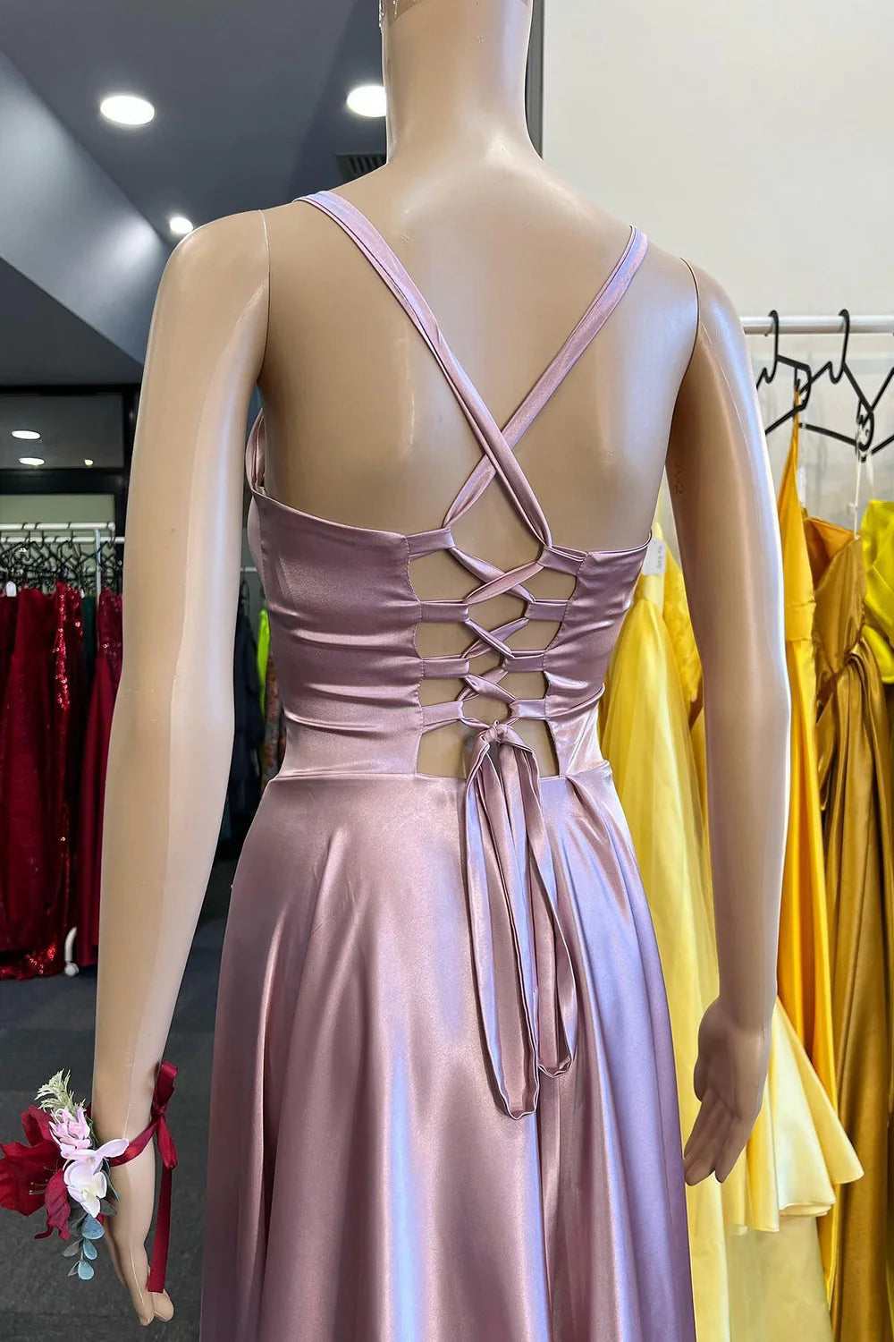 Back view of a light pink A-line long prom dress with delicate spaghetti straps.