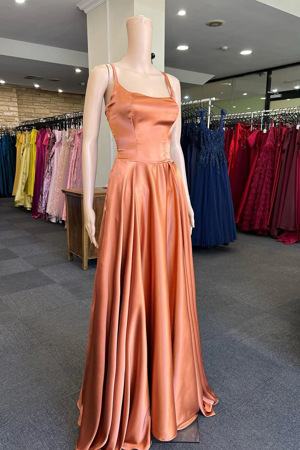 Vibrant orange A-line long prom dress with spaghetti straps.