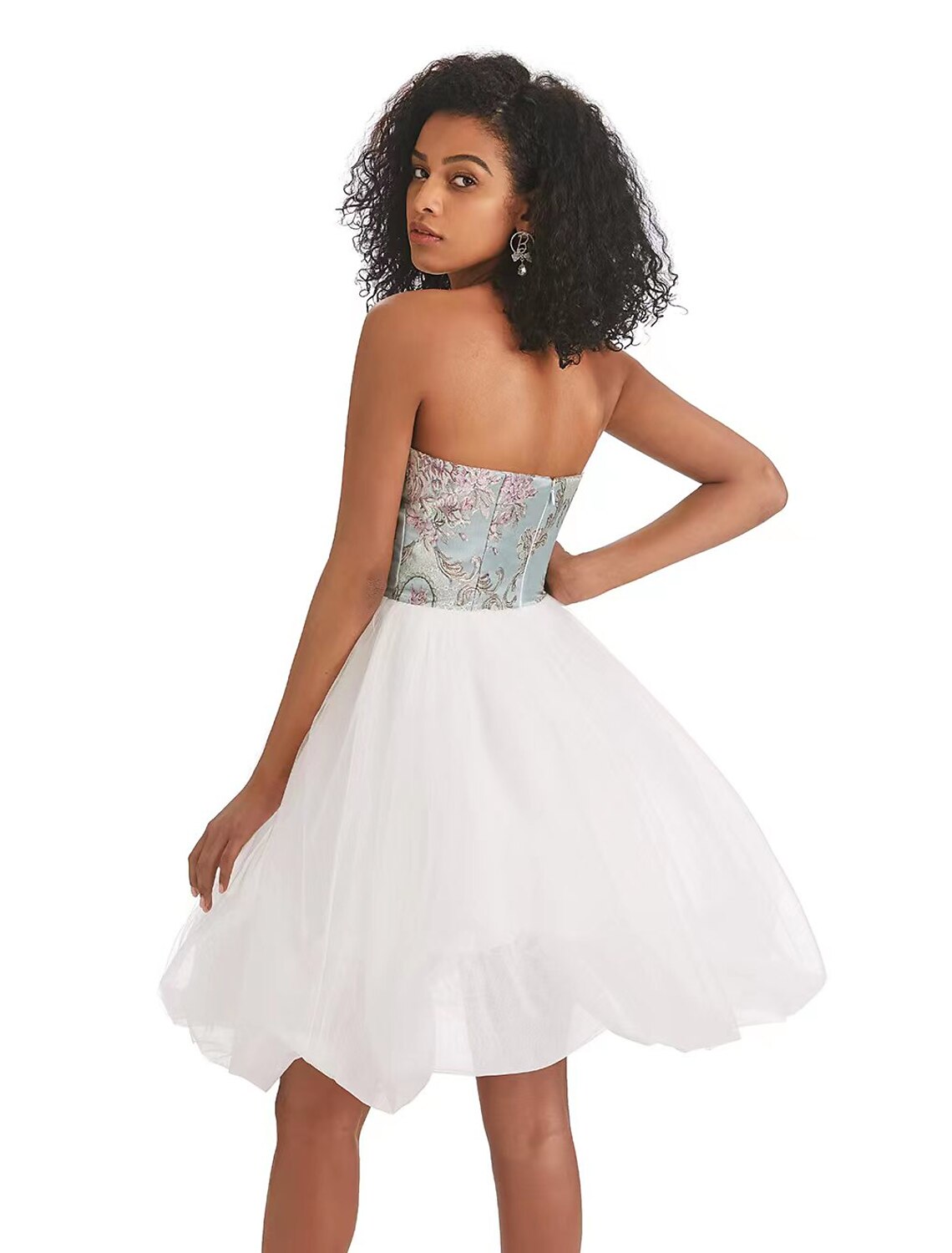 Back view of a model in a strapless A-line color block tulle dress.