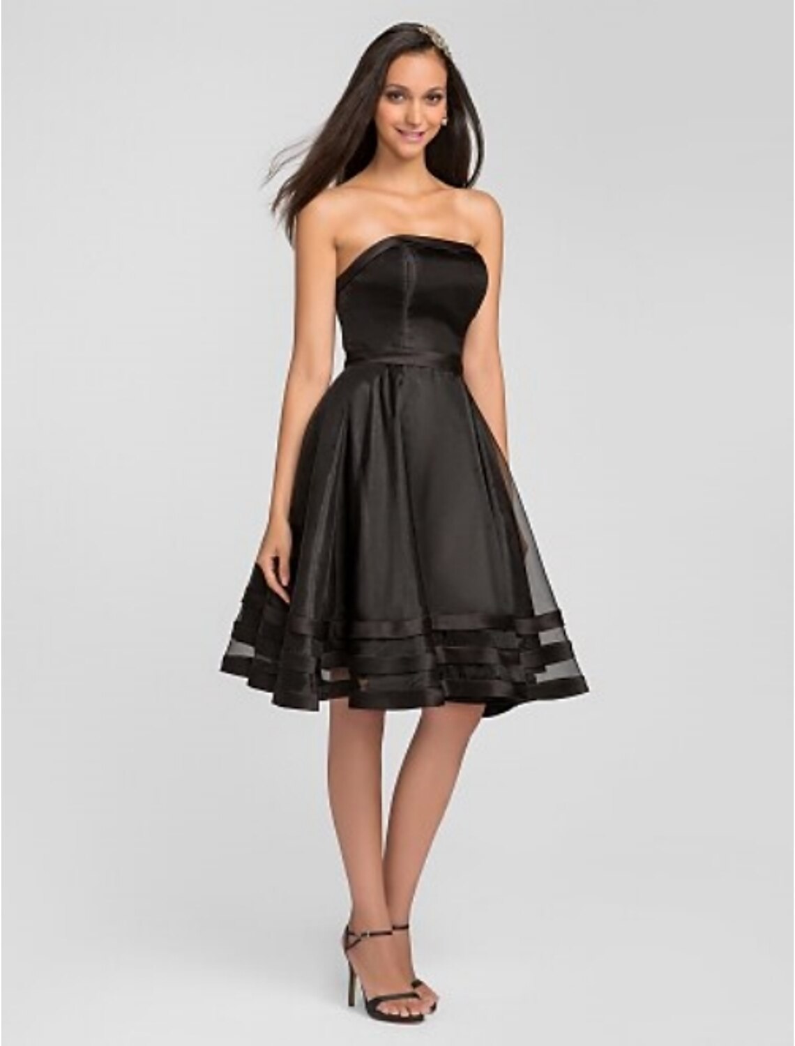 Model posing in an A-Line strapless bridesmaid dress.