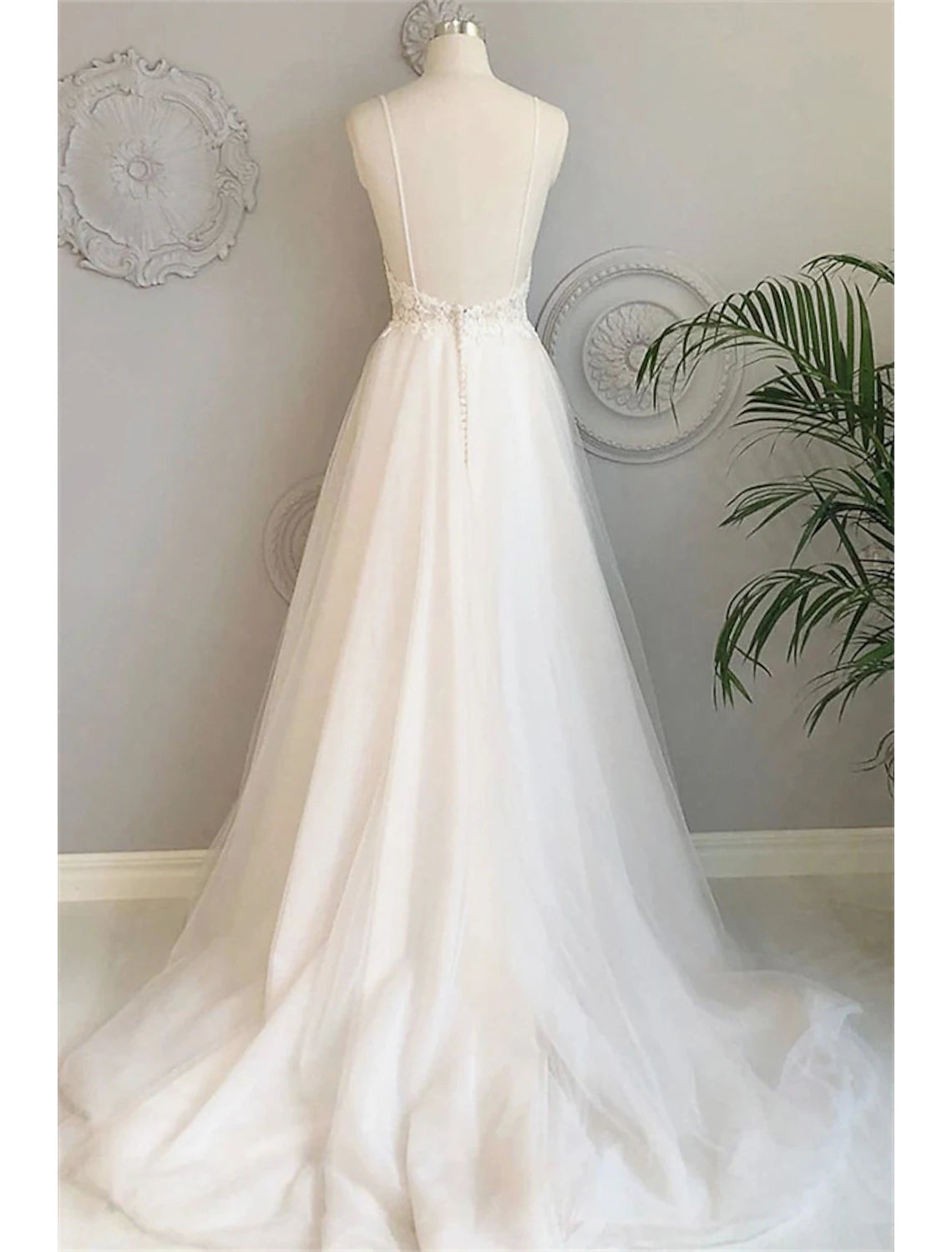 Back view of A-Line lace bridal gown with court train and button details.