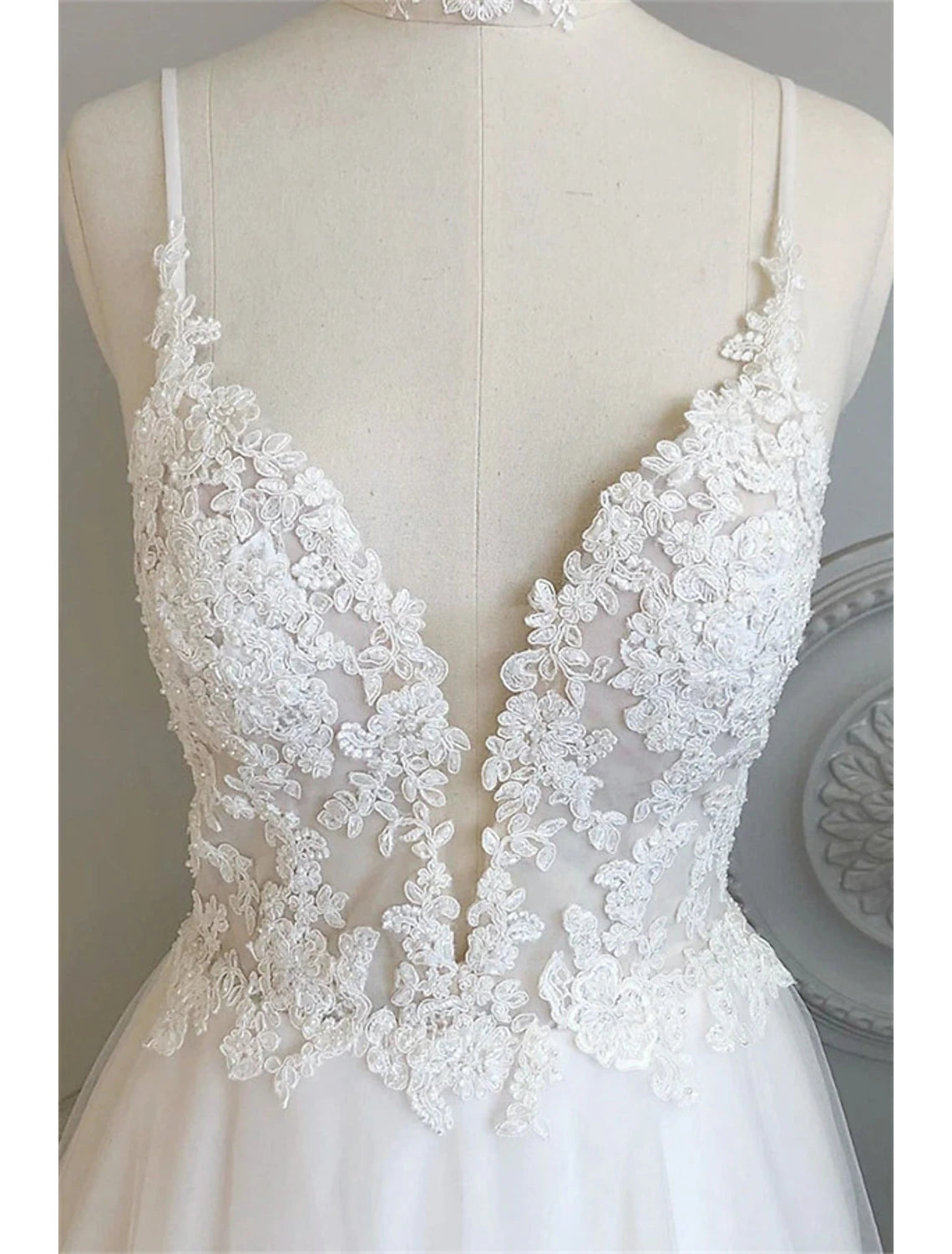 Close-up of lace appliques and button details on a beach wedding dress.