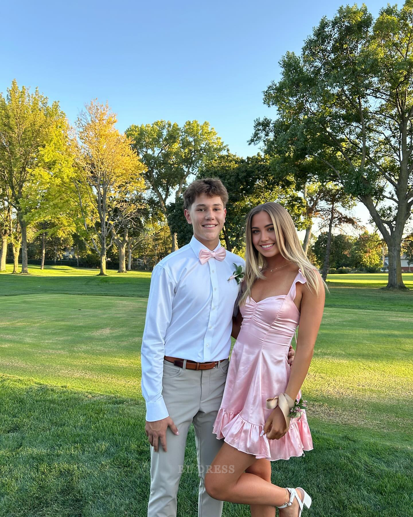 Model wearing a pink A-line sweetheart satin short homecoming dress, front view.