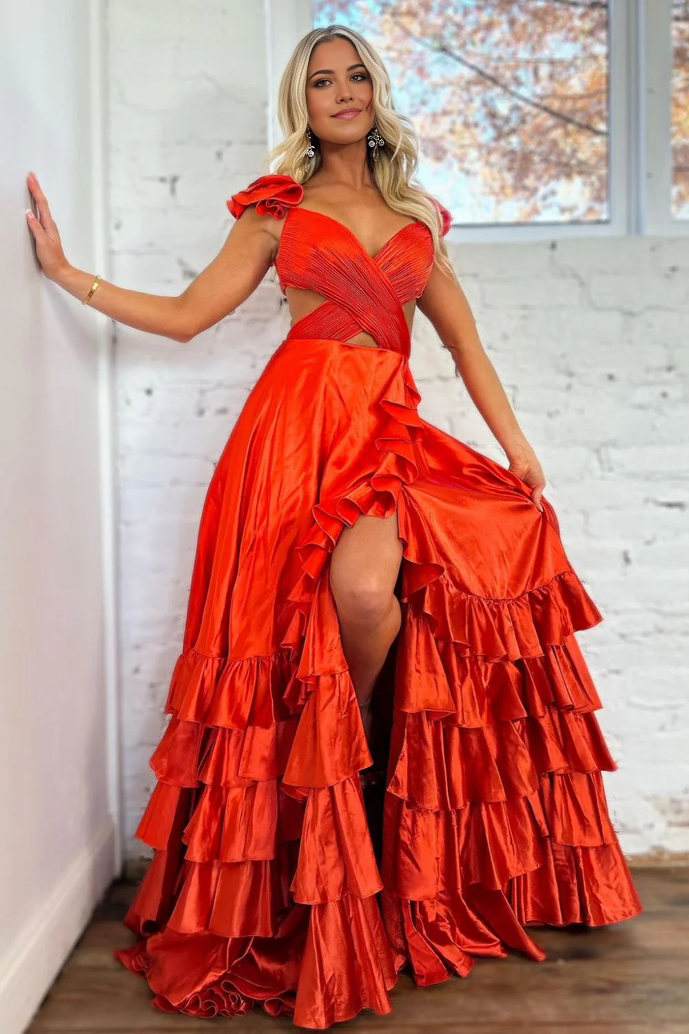Model wearing a red A-line satin prom dress with V-neck and cutout waist.