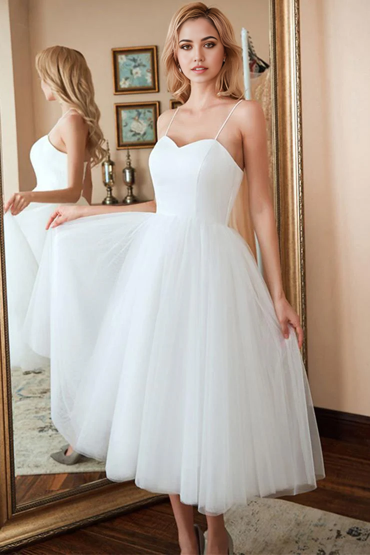 Woman wearing a short white A-line tulle dress with a V-neck and lace-up back.