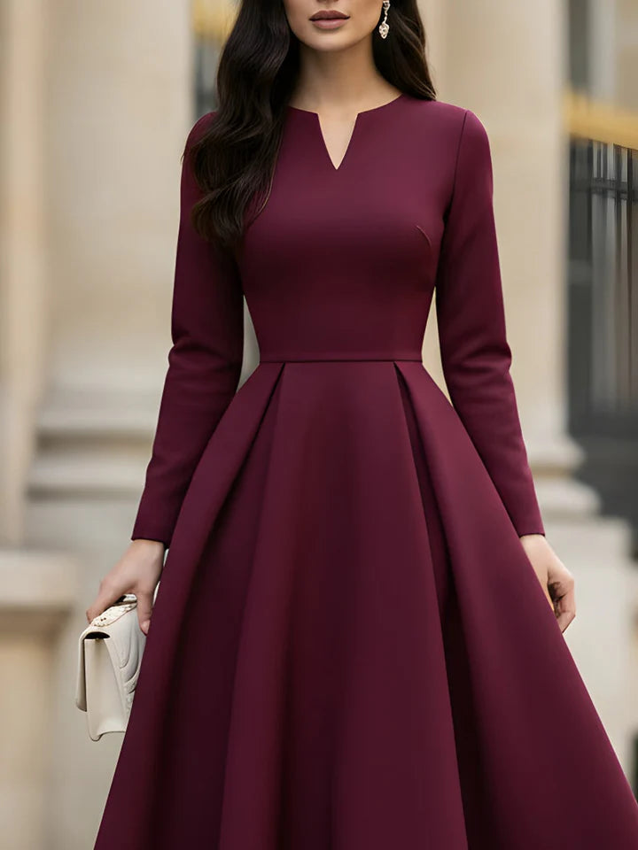 Side view of the burgundy A-line pleated tea-length dress.