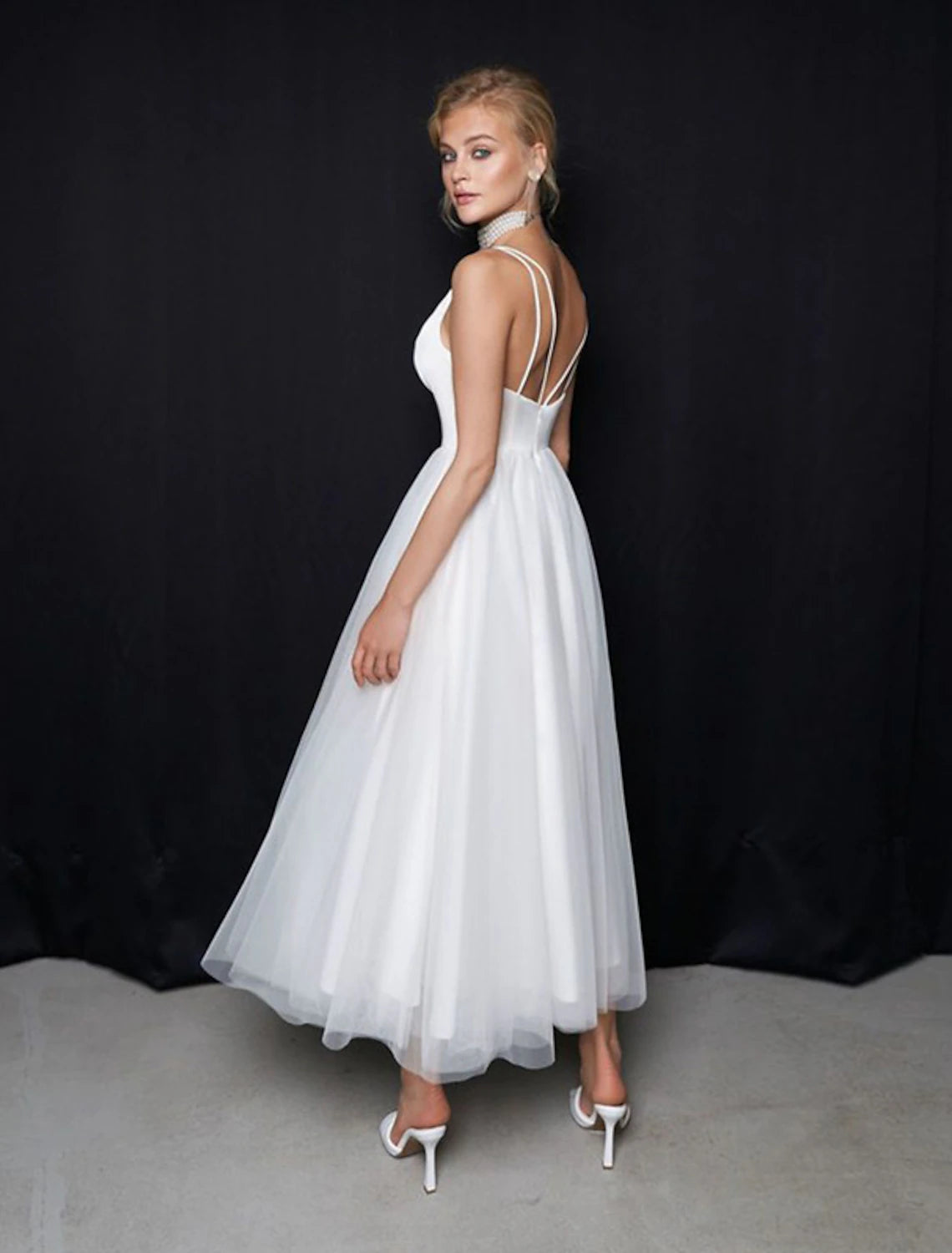 Chic white ankle-length wedding dress featuring a V-neck and delicate spaghetti straps.