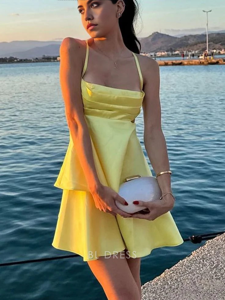 Front view of a model wearing a chic yellow A-line satin dress with spaghetti straps.