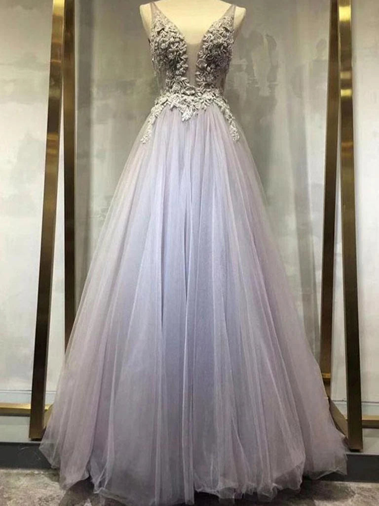 Woman wearing elegant A-line V-neck tulle lace long prom gown.