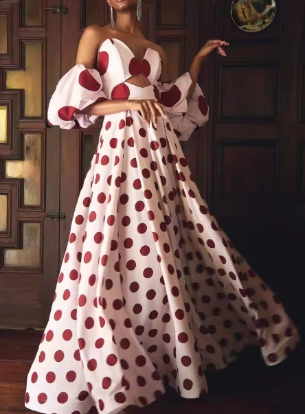 Woman wearing a chic A-line halter V-neck polka dot maxi dress, posing outdoors.