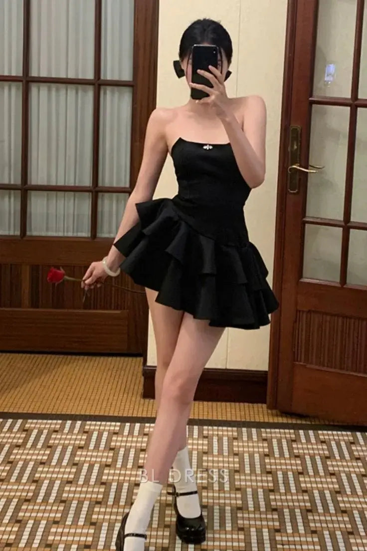 Model wearing a black satin A-line strapless short layered dress.