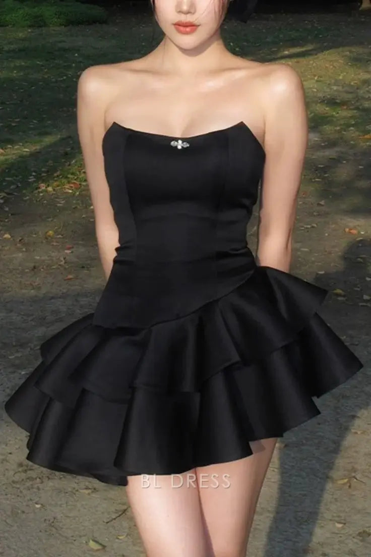Detail of the layered skirt on the black satin A-line dress.