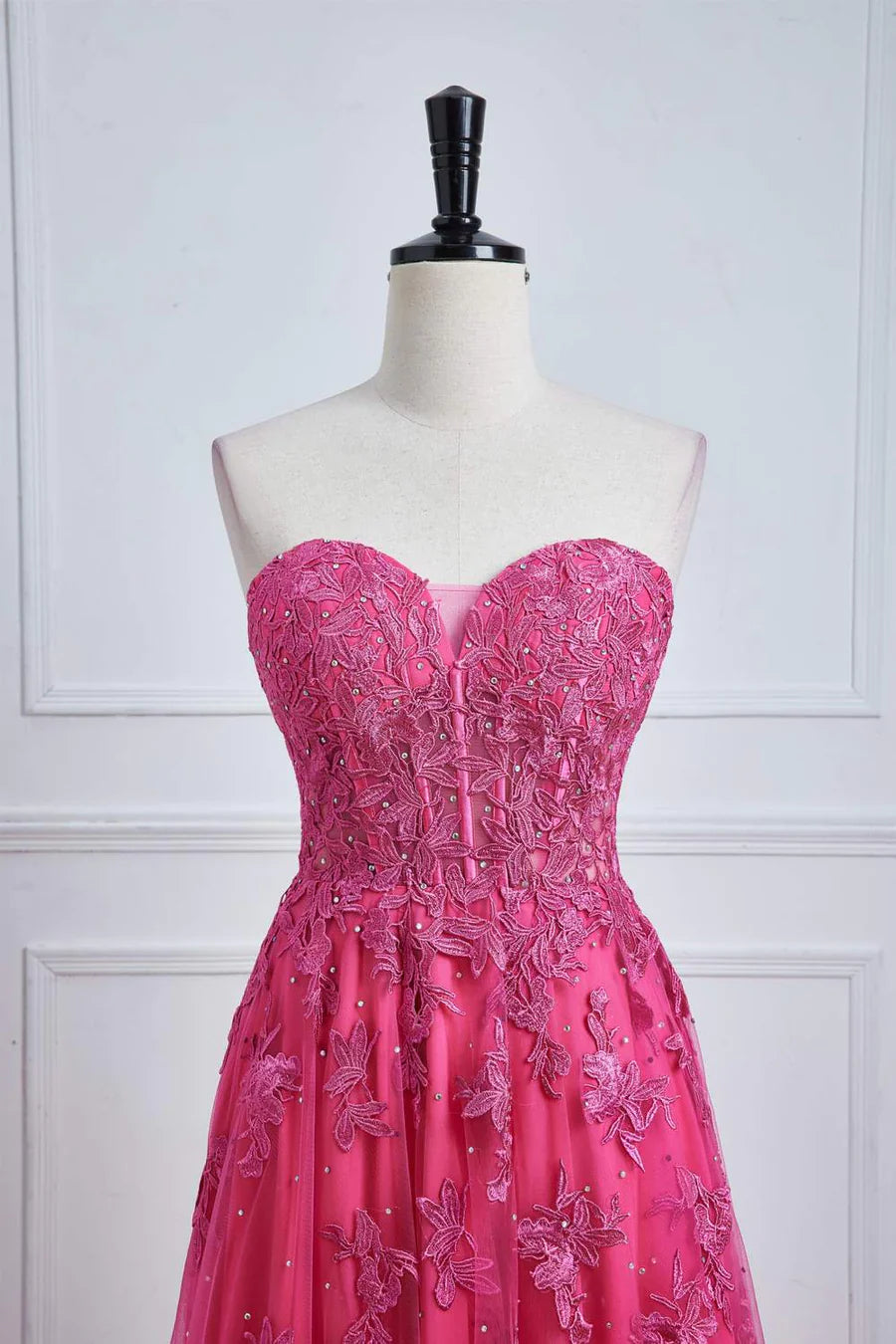 Fuchsia strapless A-line prom dress showcasing the leg slit.