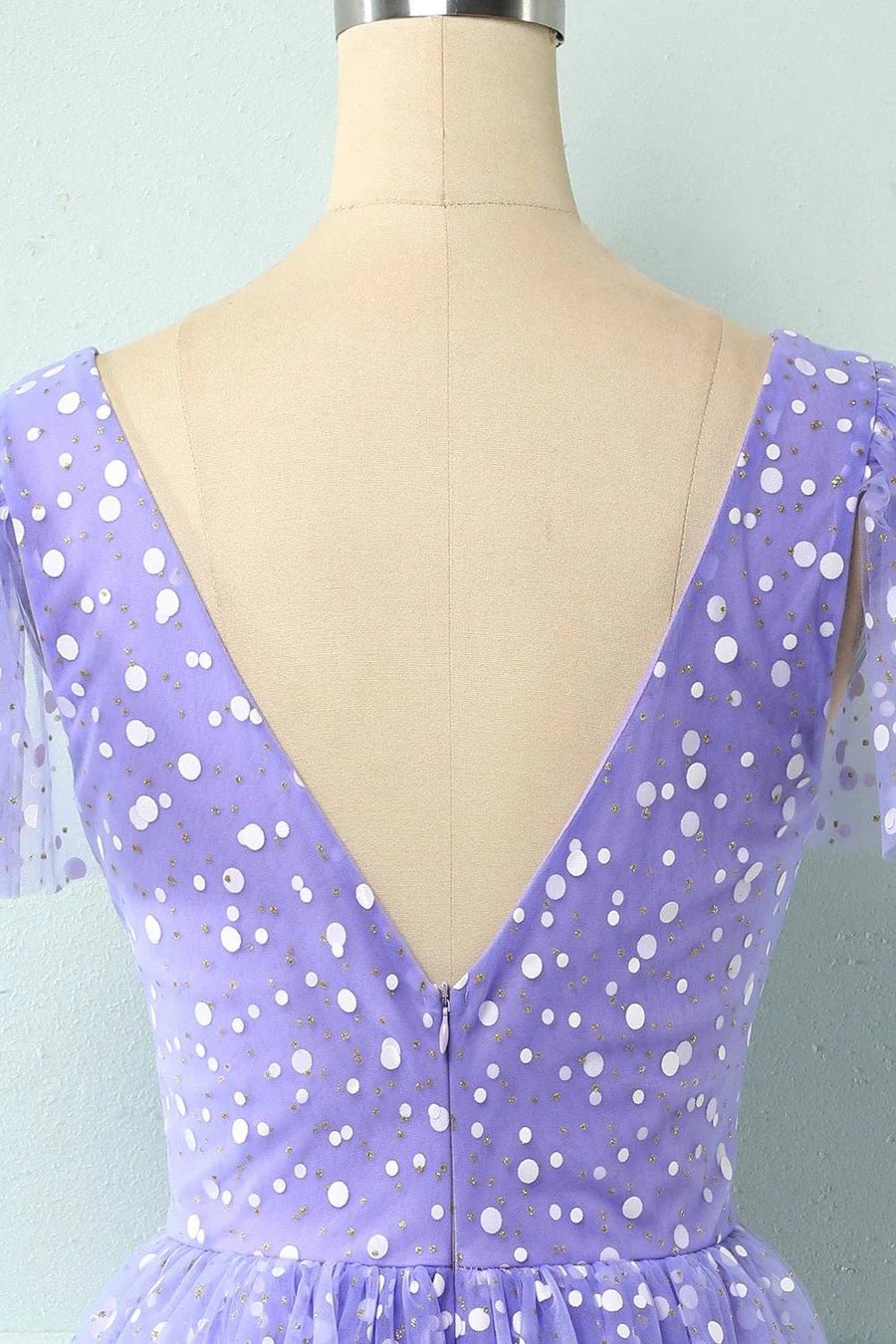 Close-up of the dotted pattern and multi-layered fabric of the mini dress.