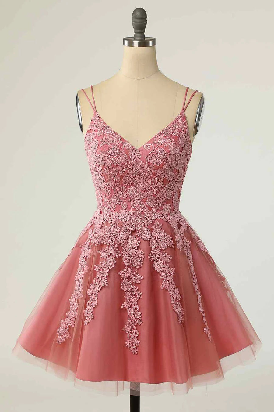 Model wearing an A-line mini homecoming dress with V-neck and double straps.