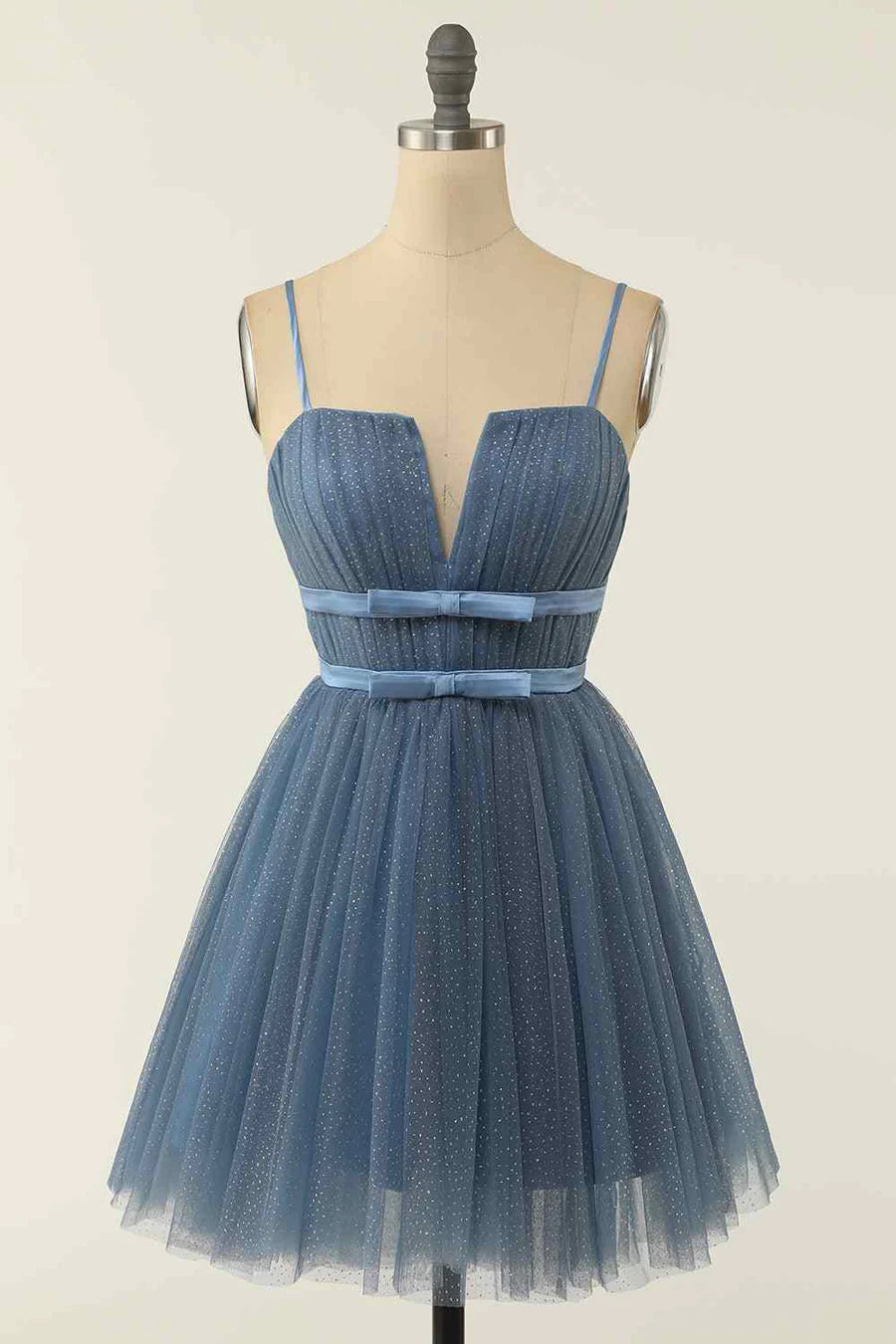 Model wearing an A-line V-neck pleated homecoming dress with a double bow tie sash.