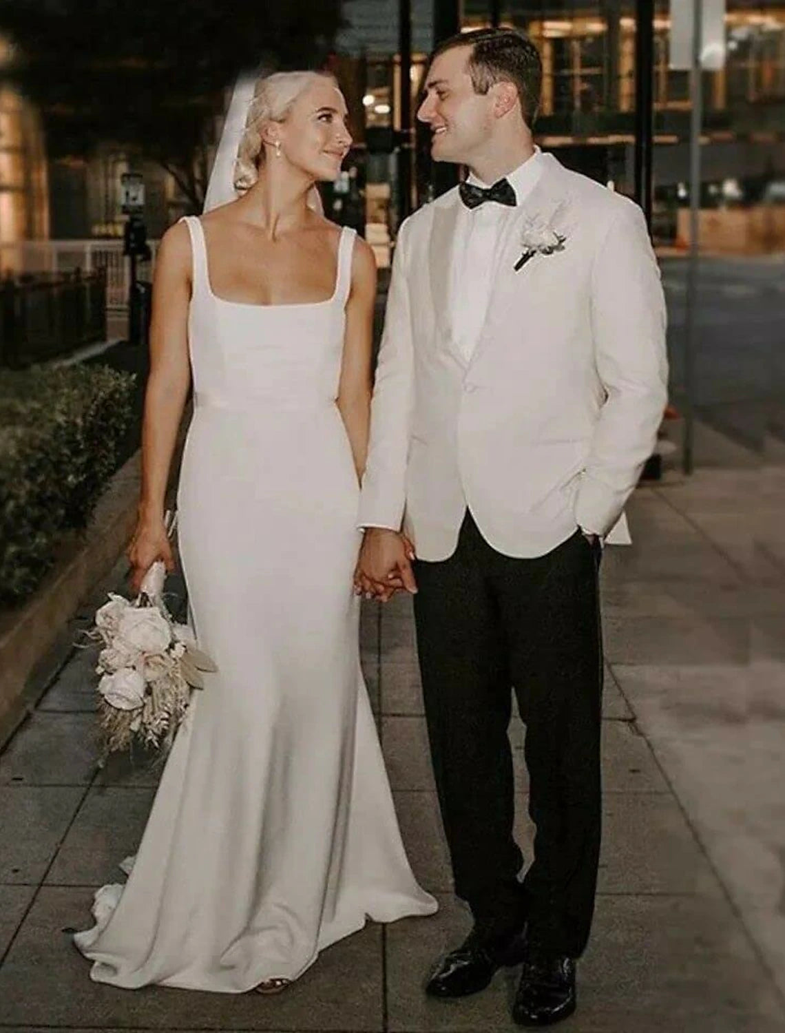 Model wearing a white beach boho mermaid wedding dress with a court train.